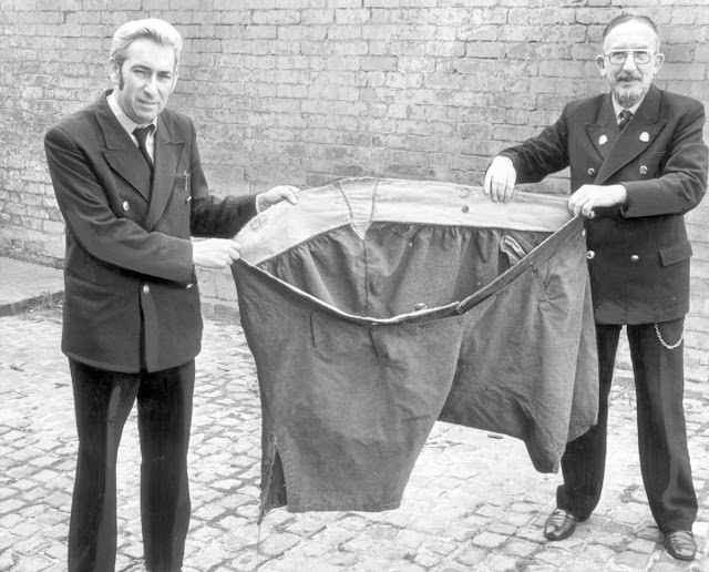 Two Men Holding Up a Pair of Oversized Trousers of Daniel Lambert, the Heaviest Man in England